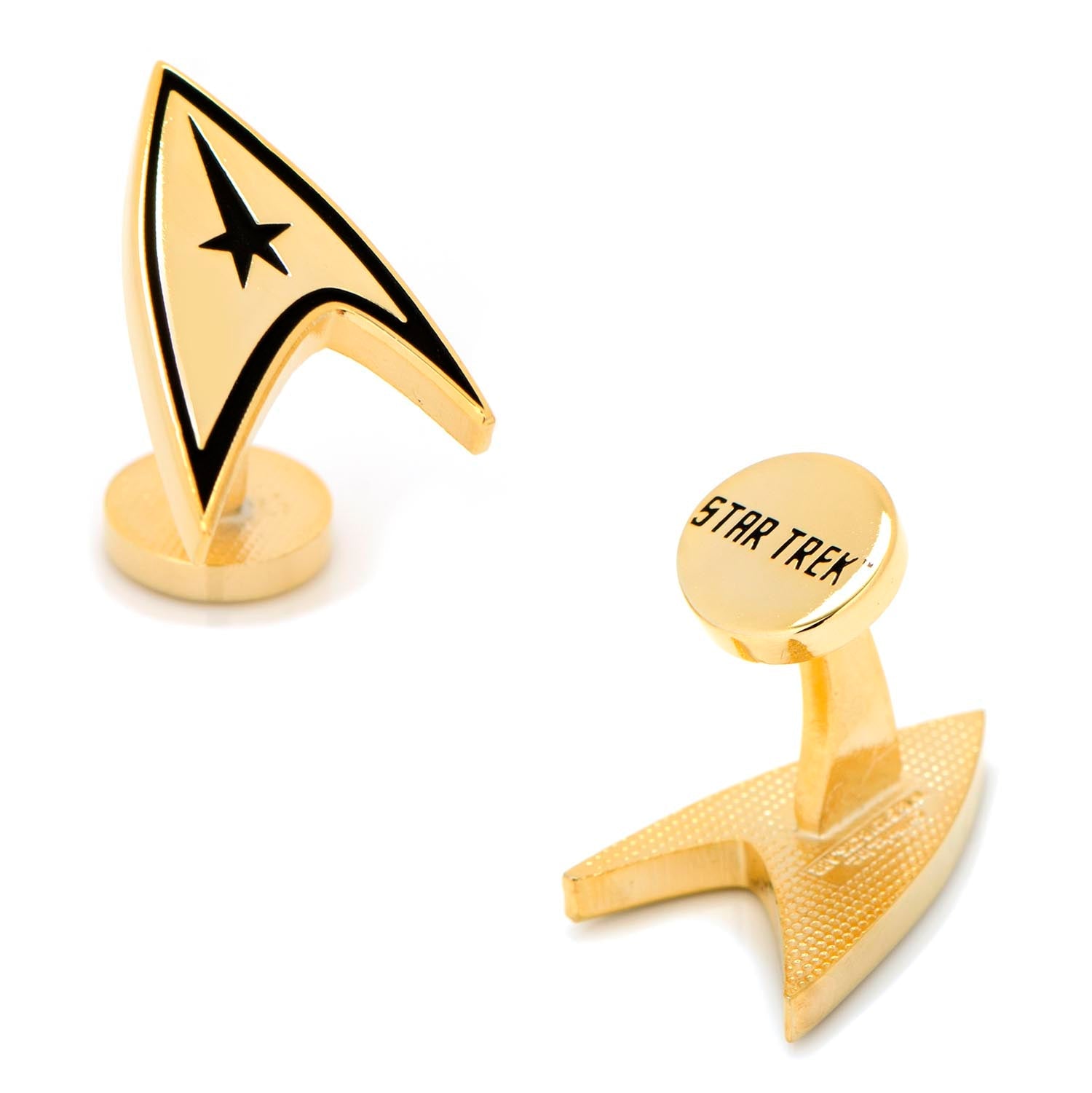 Close-up of gold-plated Star Trek Delta Shield cufflinks against a dark background