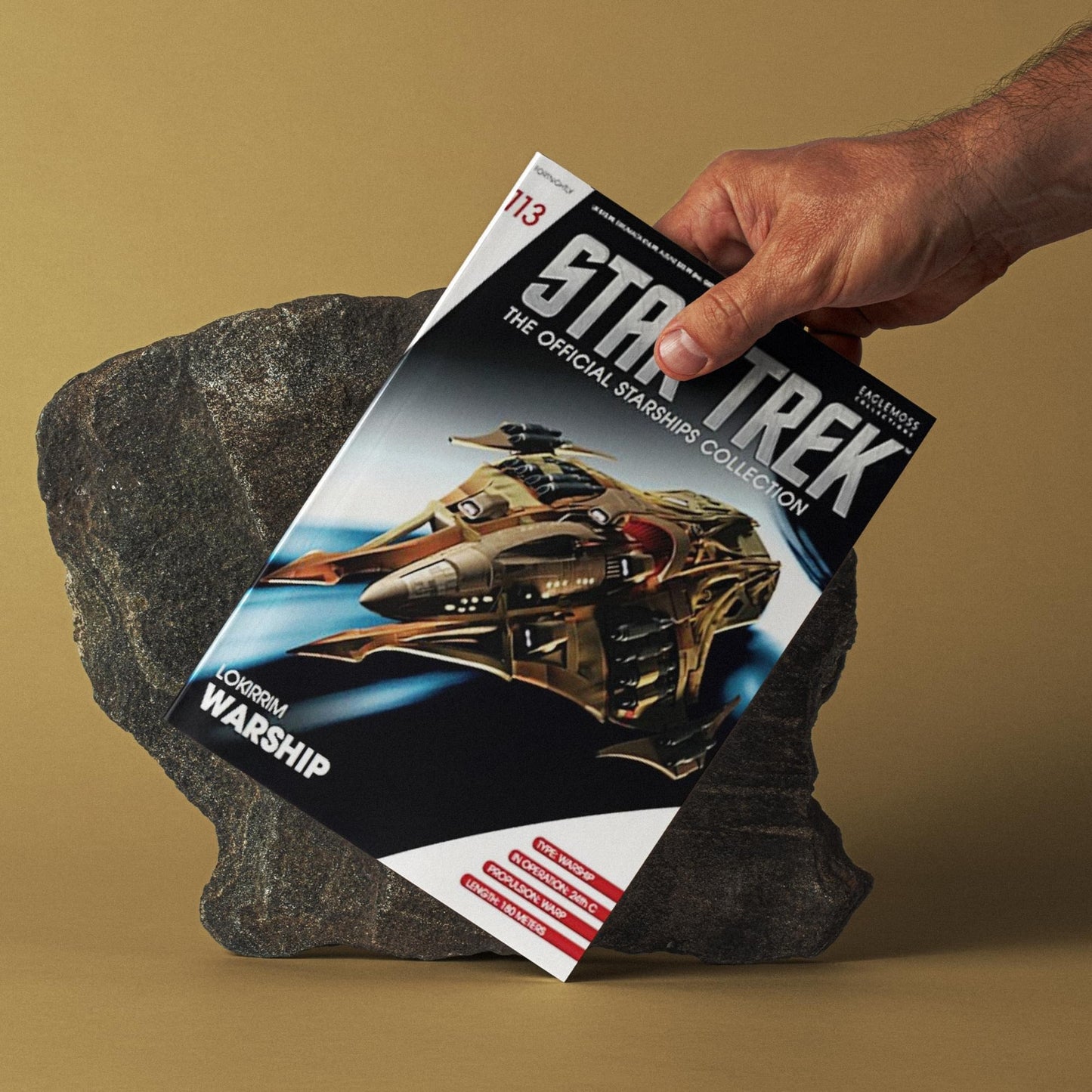 Close-up of the magazine interior showing original design sketches and production text detailing the starship